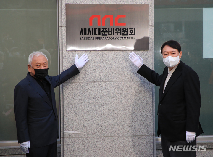 [서울=뉴시스] 김선웅 기자 = 윤석열 국민의힘 대선 후보와 김한길 새시대준비위원장이 12일 오후 서울 여의도에 위치한 새시대준비위원회에서 현판 제막식을 하고 있다. (공동취재사진) 2021.12.12. photo@newsis.com
