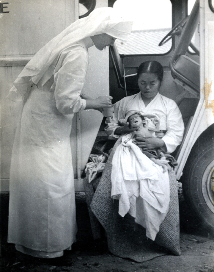[증평=뉴시스] 강신욱 기자 = 1950년대 후반 충북 증평메리놀병원에 근무했던 요안나 수녀가 몸이 아파 병원에 온 아기를 돌보고 있다. (사진=증평군 제공) 2021.12.14. photo@newsis.com *재판매 및 DB 금지