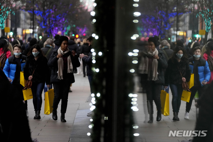 [런던(영국)=AP/뉴시스] 영국 런던 옥스포드가를 걷는 쇼핑객들의 모습이 23일(현지시간) 상점 창문에 비춰지고 있다. 2021.12.24.