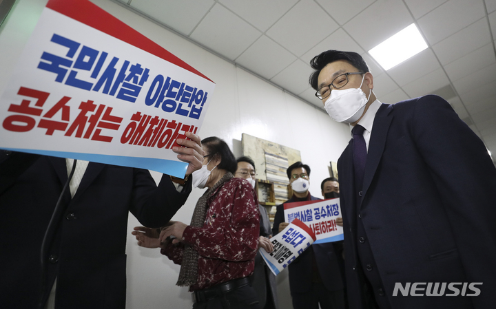 [서울=뉴시스] 최진석 기자 = 김진욱 고위공직자범죄수사처(공수처) 처장이 30일 서울 국회에서 열린 법제사법위원회 회의에 출석해 공수처 해체 촉구 피켓을 들고 의원총회를 하고 있는 국민의힘 의원들에게 인사를 위해 이동하고 있다. 2021.12.30. myjs@newsis.com