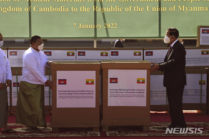 [네피도=AP/뉴시스] 훈센(오른쪽) 캄보디아 총리가 7일(현지시간) 미얀마 수도 네피도에 도착해 운나 마웅 르윈 미얀마 외교장관에게 의료 장비를 전달하고 있다. 훈센 총리는 해외 정상으로는 처음으로 지난해 쿠데타가 발생한 미얀마를 방문했다. 2022.01.07.