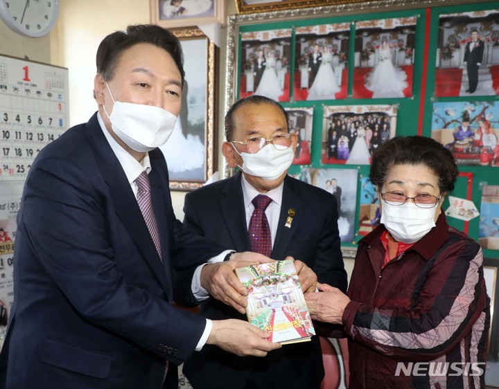 [창원=뉴시스] 김선웅 기자 = 윤석열 국민의힘 대선 후보가 14일 경남 창원시 마산합포구에 위치한 신신예식장을 방문해 무료 예식 봉사로 잘 알려진 백낙삼·최필순 부부와 만나 환담 후 기념촬영을 하고있다. 2022.01.14. mangusta@newsis.com