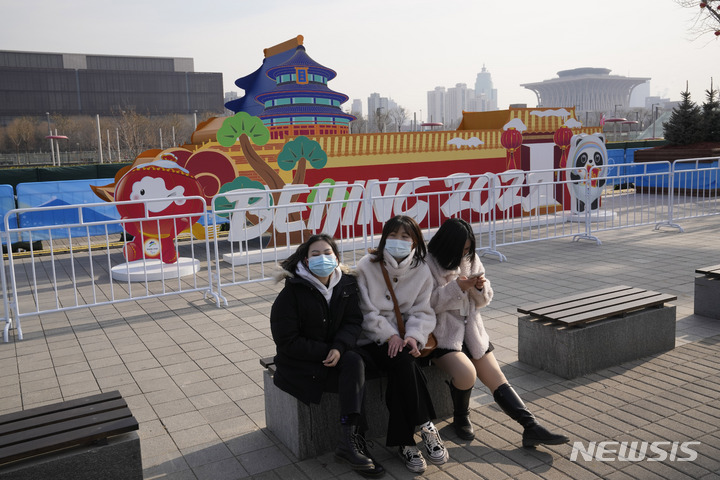 [베이징=AP/뉴시스] 중국 현지 여성들이 지난 18일 중국 베이징 올림픽 그린에 위치한 베이징 동계올림픽 구조물 앞 벤치에서 마스크를 쓰고 휴식을 취하고 있다. 2022.01.20.