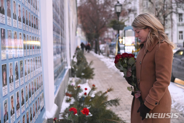 멜라니 졸리 캐나다 외무장관이 지난 18일 우크라이나 수도 키예프에서 러시아-우크라이나 전쟁 사망자 추모벽에 헌화하는 모습. (우크라이나 외무부 제공=AP/뉴시스)