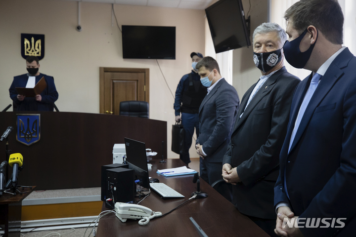 [키예프=AP/뉴시스] 19일(현지시간) 페트로 포로셴코 우크라이나 전 대통령(오른쪽에서 두번째) 키예프의 법정에 출석한 모습. 이날 우크라이나 법원은 검찰이 청구한 구속영장을 기각했다. 2022.01.20 