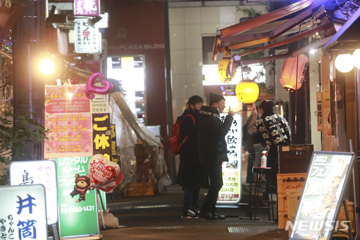 [도쿄(일본)=AP/뉴시스]일본에서 코로나19 신규 확진자가 급속도로 늘어나자 지방 정부들도 급증하는 코로나 감염 사태에 대처하기 위한 노력을 강화하고 있다. 자료사진은 코로나바이러스 확산을 막기 위해 마스크를 쓴 사람들이 지난 1월21일 도쿄의 술집과 식당들이 줄지어 있는 거리를 걷고 있는 모습. 2022.07.25.
