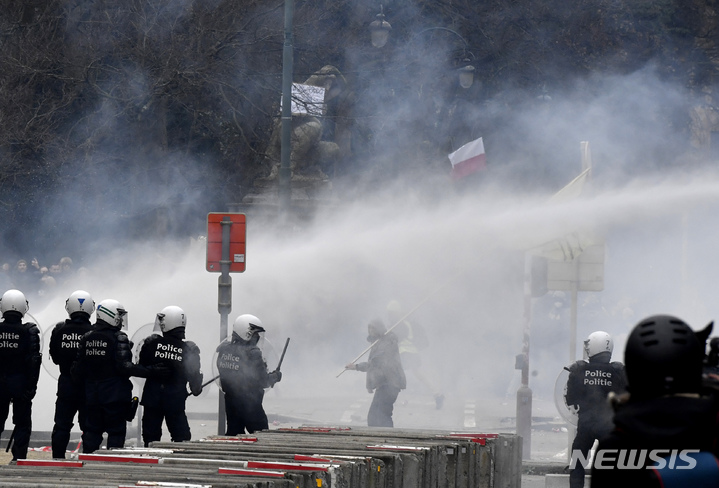 [브뤼셀( 벨기에)=AP/뉴시스] 23일(현지시간) 브뤼셀 시내에서 백신패스 등 코로나 방역수칙에 항의하는 5만여명의 시위대가 경찰과 충돌하면서, 경찰이 물대포와 최루 가스를 발사하며 진압하고 있다.  