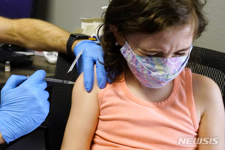 [캘리포니아(미국)=AP/뉴시스]지난달 25일 미국 캘리포니아주 새크라멘토에 위치한 한 후치 약국에서 어린이 매케나 브라운(10)이 코로나19 백신을 접종 받으며 고개를 돌리고 있다. 2022.02.01.