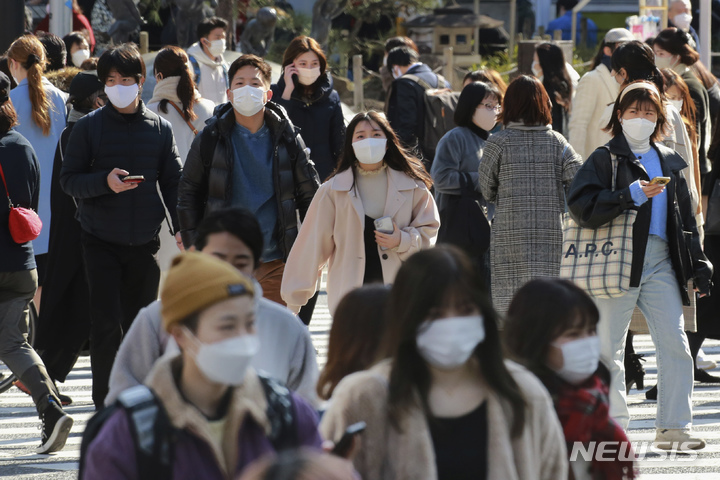 [도쿄(일본)=AP/뉴시스]지난 2일 일본 도쿄의 한 횡단보도를 코로나19 감염예방을 위해 마스크를 착용한 시민들이 건너고 있다. 2022.02.09.