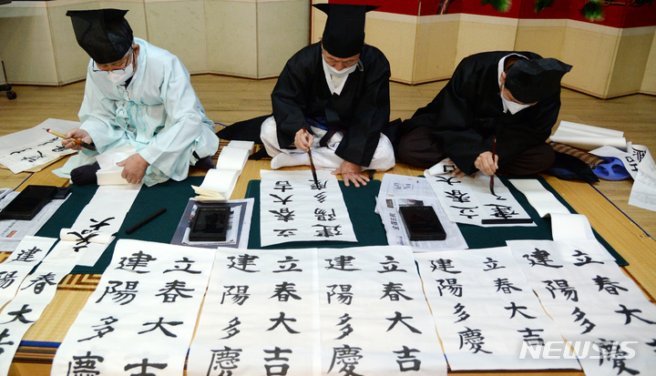 [전주=뉴시스] 김얼 기자 = 24절기 중 첫 번째 절기인 입춘(立春)을 하루 앞둔 3일 전북 전주시 전주향교에서 관계자들이 입춘첩을 작성하고 있다. 2022.02.03. pmkeul@nwsis.com