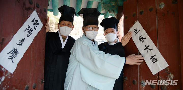 [전주=뉴시스] 김얼 기자 = 24절기 중 첫 번째 절기인 입춘(立春)을 하루 앞둔 3일 전북 전주시 전주향교에서 관계자들이 입춘첩을 붙이고 있다. 2022.02.03. pmkeul@nwsis.com