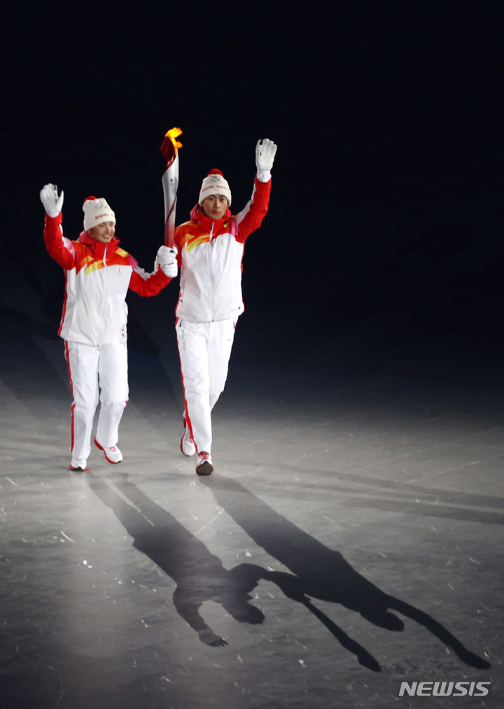 [베이징(중국)=뉴시스] 김병문 기자 = 4일 오후 중국 베이징국립경기장에서 열린 2022 베이징 동계올림픽 개막식에서 최종 성화 주자인 디니걸 이라무장과 자오자원이 성화대를 향해 나아가고 있다. 2022.02.04. dadazon@newsis.com