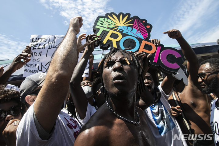[리우데자네이루( 브라질) =AP/뉴시스] 브라질 리우데자네이루 시의 시위대가 콩고출신 흑인 이민청년이 살해된 해변 매점의 간판을 2월 5일 끌어내리면서 흑인생명도 소중하다고 외치고 있다. 