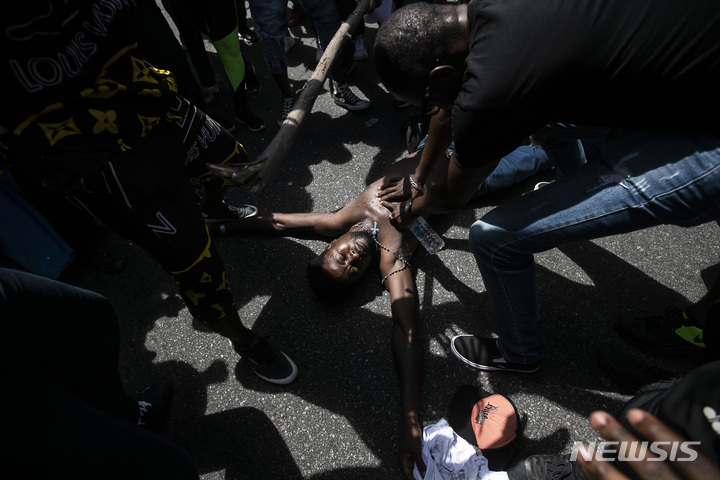 [리우데자네이루( 브라질) =AP/뉴시스] 브라질 시위대가 콩고출신 24세 이민청년의 피살장면을 재연하며 5일 항의시위를 벌이고 있다. 