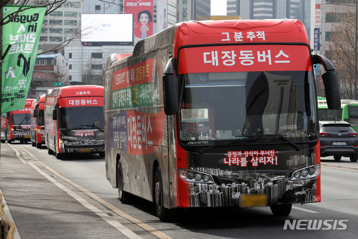 [서울=뉴시스] 조성우 기자 = 대장동버스 연합 참여자들이 7일 오전 서울 중구 서울시청 앞 광장에서 '대장동게이트 주범 구속 처벌 촉구 민심 대장동버스 연합 출정식'을 하고 있다. 2022.02.07. xconfind@newsis.com