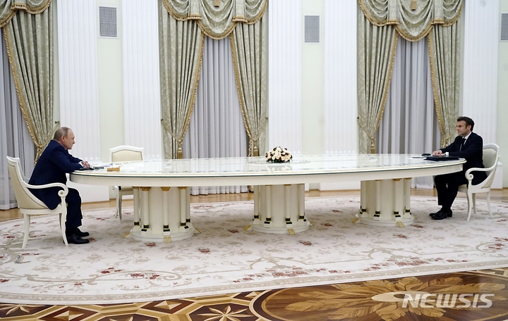 [모스크바=AP/뉴시스]블라디미르 푸틴(왼쪽) 러시아 대통령과 에마뉘엘 마크롱 프랑스 대통령이 7일(현지시간) 모스크바 크렘린궁에서 긴 테이블을 사이에 두고 정상회담을 하고 있다. 2022.02.08.