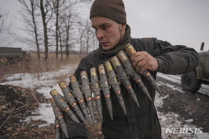 [도네츠크=AP/뉴시스] 한 우크라이나군 병사가 10일(현지시간) 우크라이나 동부 도네츠크 지역의 합동작전 통제구역에서 훈련 중 대구경 탄약을 옮기고 있다. 2022.02.11.