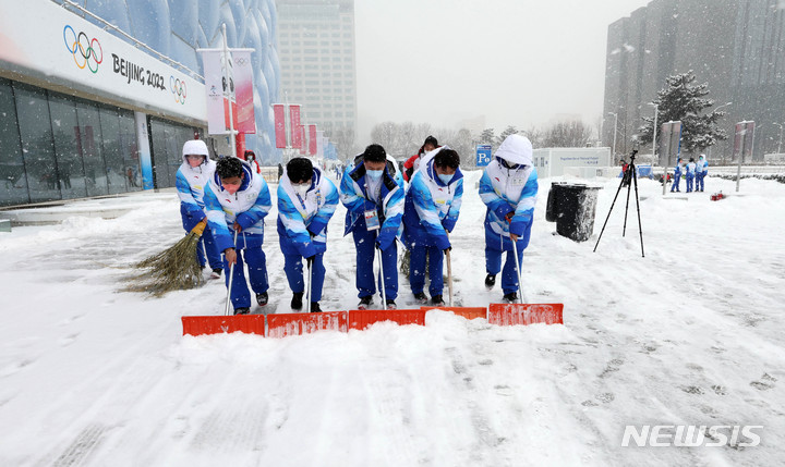 [베이징(중국)=뉴시스] 고범준 기자 = 2022 베이징 동계올림픽이 진행중인 13일 중국 베이징 내셔널 아쿠아틱 센터에서 자원봉사자 및 관계자들이 눈을 치우고 있다. 2022.02.13. bjko@newsis.com