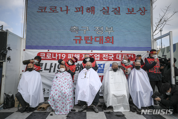 [서울=뉴시스] 정병혁 기자 = 코로나피해자영업총연합 회원들이 15일 오후 서울 종로구 광화문시민열린마당에서 열린 코로나 피해 실질 보상 촉구 정부 규탄대회에서 삭발을 하고 있다. 2022.02.15. jhope@newsis.com