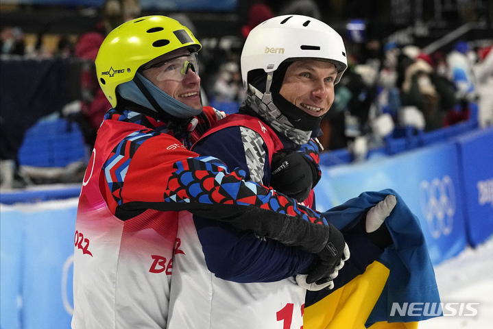 [장자커우=AP/뉴시스] 16일 2022 베이징 동계올림픽 스키 남자 에어리얼 경기에서 올렉산드르 아브라멘코(우크라이나)의 은메달 수상이 확정되자 일리야 부로프(러시아올림픽위원회)가 축하의 포옹을 건네고 있다. 2022.02.16.