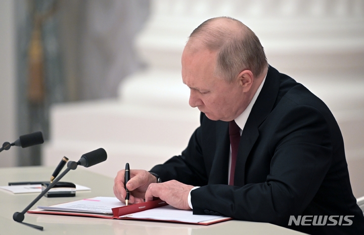 [모스크바=AP/뉴시스] 블라디미르 푸틴 러시아 대통령이 21일(현지시간) 수도 모스크바 크렘린궁에서 우크라이나 동부 분쟁 지역인 돈바스 지역(도네츠크, 루한스크)의 독립을 인정하는 문서에 서명하고 있다. 2022.02.22.
