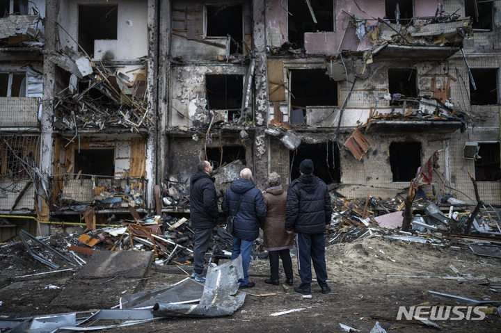 [키예프=AP/뉴시스] 25일(현지시간) 우크라이나 키예프에서 주민들이 러시아의 로켓 공격으로 파손된 건물을 살펴보고 있다. 2022.02.25.