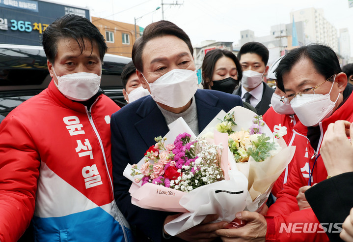 [인천=뉴시스] 전신 기자 = 윤석열 국민의힘 대선 후보가 26일 인천 서구 검단사거리에서 열린 유세에서 지지자로부터 꽃다발을 받고 있다. (공동취재사진) 2022.02.26. photo@newsis.com