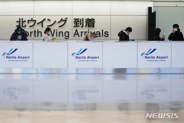 [나리타=AP/뉴시스]지난해 12월 2일 일본 나리타 국제공항의 국제선 도착 게이트에서 마스크를 착용한 승객들이 줄을 서고 있다. 2022.05.17.