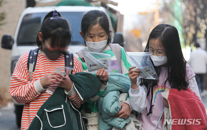 [서울=뉴시스] 지난달 2일 오후 서울 시내 초등학교에서 학생들이 자가진단키트를 살펴보며 하교하고 있다. (사진=뉴시스DB). 2022.04.20. photo@newsis.com