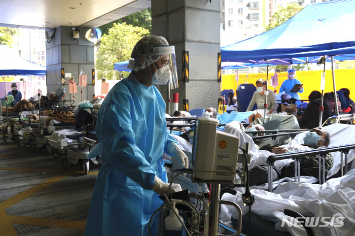[홍콩=AP/뉴시스] 2일(현지시간) 홍콩의 카리타스 병원 밖 임시 대기소에 마련된 병상에서 환자들이 진료를 기다리고 있다. 넘치는 코로나19 환자로 병원에 과부하가 걸려 일부 환자들은 병원 밖에서 대기하는 상황이 벌어지고 있다. 2022.03.02.
