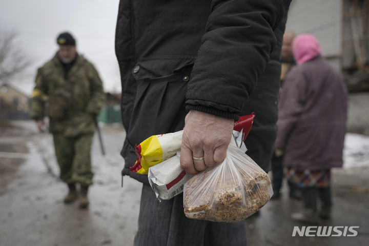 [키이우=AP/뉴시스] 2일(현지시간) 러시아의 공습으로 피해를 본 우크라이나 수도 키이우 외곽의 고렌카에서 한 주민이 음식 꾸러미를 들고 있다. 2022.03.03.
