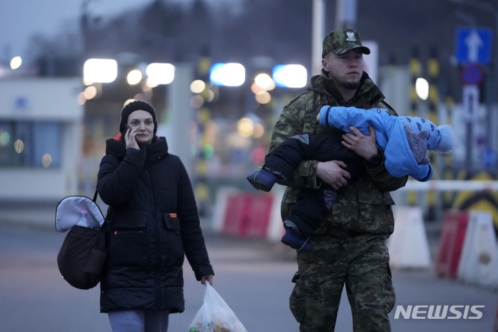 [메디카=AP/뉴시스] 2일(현지시간) 한 폴란드 군인이 폴란드 남동부 메디카국경에 도착한 한 우크라이나 난민을 도와 그의 아이를 안아 이동하고 있다. 유엔난민기구는 러시아의 우크라이나 침공 7일 만에 87만4000명의 우크라이나인이 우크라이나를 떠났으며 곧 100만 명을 넘어설 것이라고 전했다. 2022.03.03.