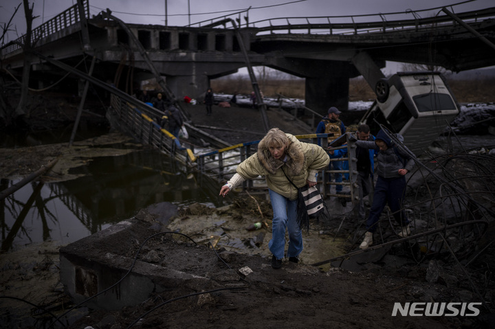 [크이우=AP/뉴시스] 2일(현지시간) 우크라이나 수도 크이우 외곽에서 우크라이나인이 파손된 다리를 건너고 있다. 2022.03.03.