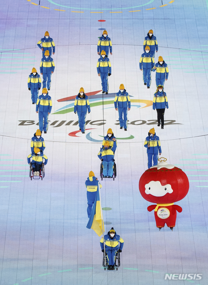 [베이징=AP/뉴시스] 4일 중국 베이징 국립경기장에서 열린 2022 베이징 동계패럴림픽 개회식에서 우크라이나 막심 야로비 선수가 국기를 들고 입장하고 있다. 2022.03.04.