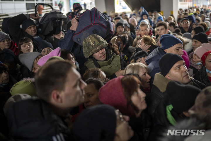 [키이우=AP/뉴시스] 3월4일(현지시간) 우크라이나 키이우 역에서 피난민들이 리비우 행 열차를 타려고 몰려들자 한 군인이 이들을 힘겹게 통제하고 있다. 우크라이나 남성들은 여성과 아이들이 이웃 국가로 피난 가는 동안 러시아와의 전쟁에서 싸우기 위해 남아 있어야 한다. 2022.03.05.