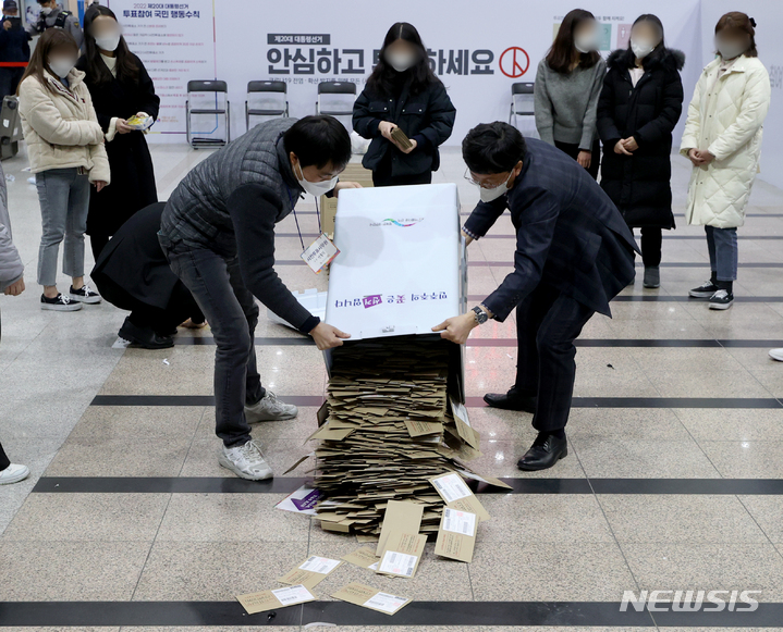 [서울=뉴시스] 김병문 기자 = 제20대 대통령 선거 사전투표가 끝난 지난 5일 오후 서울역에 설치된 남영동 사전투표소에서 관계자들이 투표함을 열고 있다. 2022.03.05. dadazon@newsis.com