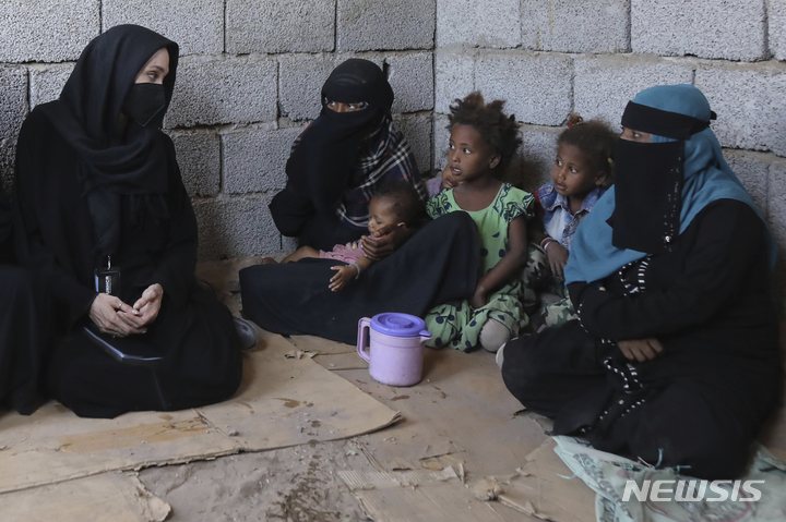 [알칸담=AP/뉴시스] 유엔 난민 고등판무관이자 배우인 앤젤리나 졸리(왼쪽)가 6일(현지시간) 예멘 알 칸담에 있는 예멘 난민 임시 수용소를 방문해 난민 가족과 얘기하고 있다. 졸리는 난민 가족에 연대를 보여주고 다가올 기금 모금 회의에서 지지를 얻기 위해 전쟁으로 만신창이가 된 예멘을 방문했다. 2022.03.07.