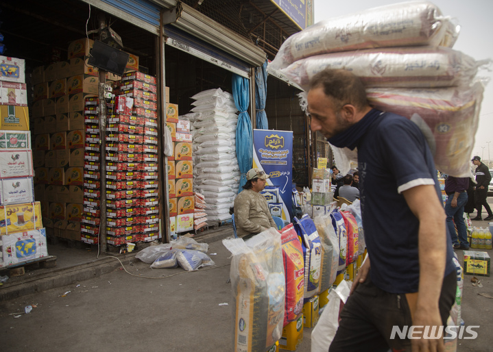 [바그다드=AP/뉴시스] 9일(현지시간) 이라크 바그다드의 자밀라 시장에서 노동자들이 식품 꾸러미를 나르고 있다. 우크라이나의 전쟁 상황으로 이라크의 식량, 연료, 건설 자재 등의 가격이 20~50% 올랐다. 2022.03.10.