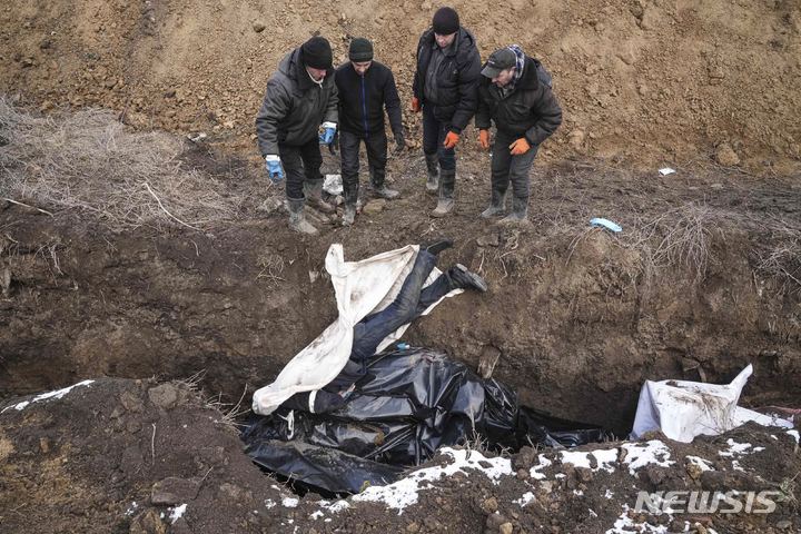 [마리우폴=AP/뉴시스] 지난 9일 우크라이나 마리우폴 외곽에서 주민들이 러시아군의 포격으로 숨진 사람들의 시신을 집단 매장하고 있다. 마리우폴은 일주일 전부터 전기와 수도가 끊긴 것으로 알려졌다. 2022.03.10.