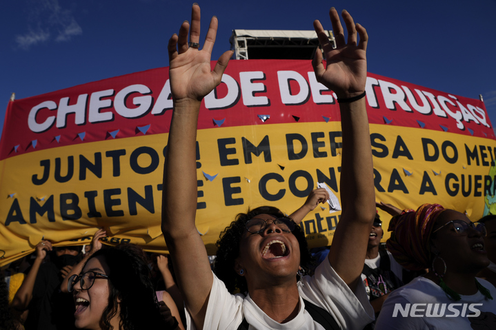 [브라질리아= AP/뉴시스] 자이르 보우소나루 대통령의 아마존 개발 훼손입법에 반대하는 원주민과 시민단체 시위대가 3월9일 브라질 국회의사당 앞에서 법안의 통과를 막는 집회와 시위를 벌이고 있다.  