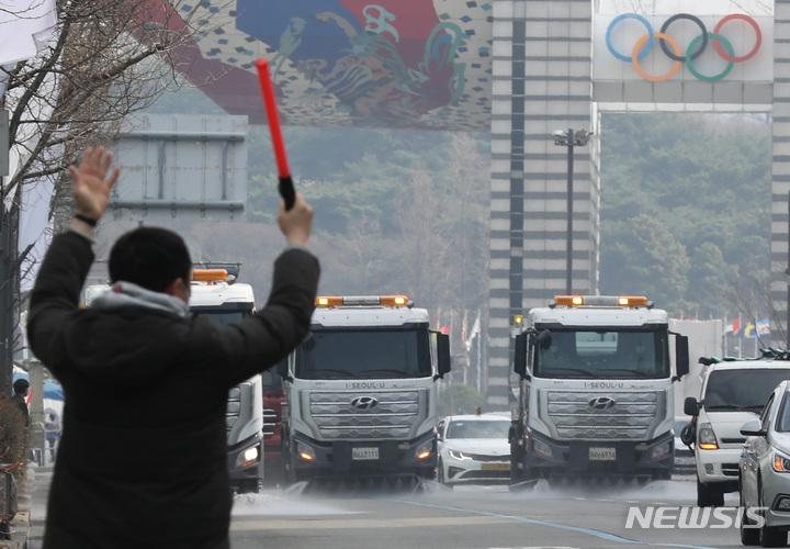 [서울=뉴시스] 조수정 기자 = 서울 송파구청 직원들이 살수차를 이용해 송파구청부터 올림픽공원 정문까지 이어지는 도로에서 봄맞이 물청소를 하고 있다. 2022.03.15. chocrystal@newsis.com