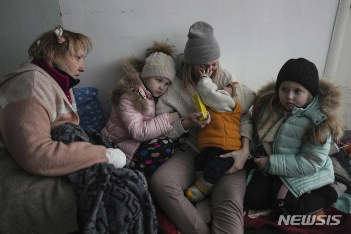 [마리우폴=AP/뉴시스] 11일 우크라이나 마리우폴의 한 병원 복도 바닥에 여성과 아이들이 앉아있다. 마리우폴은 일주일 넘게 전기, 가스, 수도 없이 러시아군에 포위돼 있다. 2022.03.16. *재판매 및 DB 금지