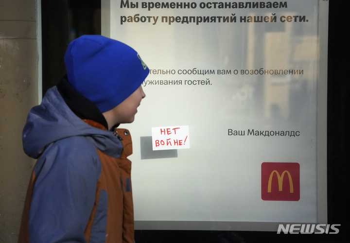 [상트페테르부르크=AP/뉴시스] 지난 3월15일(현지시간) 러시아 상트페테르부르크에서 한 소년이 폐점을 알리는 문구와 "전쟁 반대"라는 메모가 붙은 맥도날드 매장 앞을 지나고 있다.