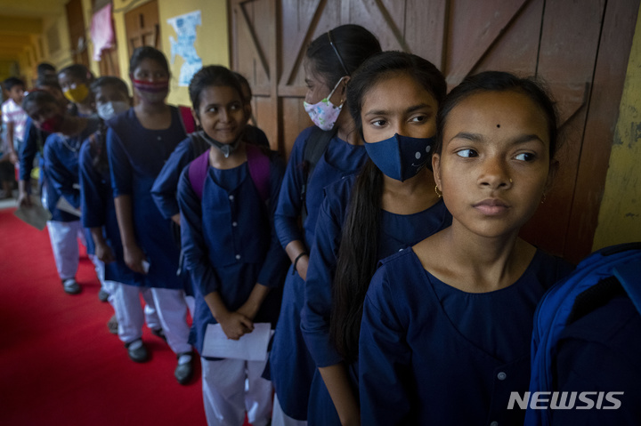 [가우하티=AP/뉴시스] 지난 3월16일(현지시간) 인도 가우하티의 한 학교에서 코르베백스 백신을 접종하려는 학생들이 줄을 서 있다. 