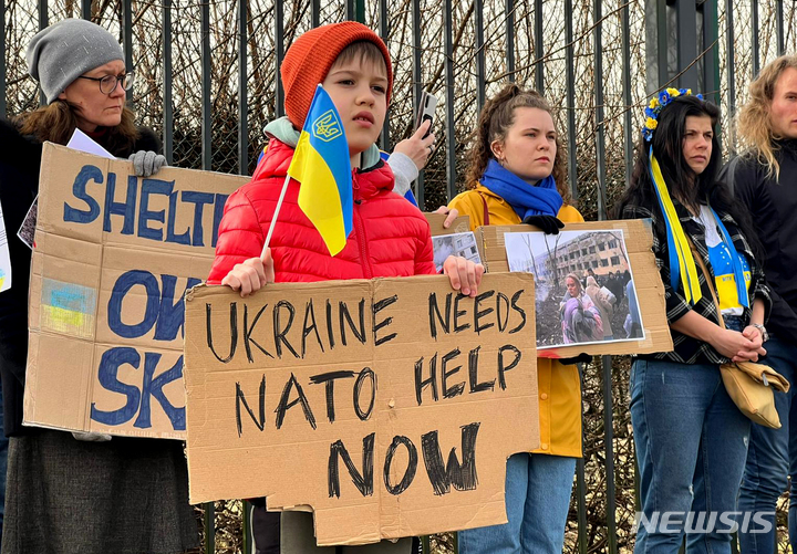 [ 브뤼셀= AP/뉴시스]러시아의 우크라이나 침공에 항의하는 유럽 시위대가 16일 나토(NATO) 본부 앞에서 우크라이나에 지원을 요구하는 시위를 벌이고 있다. 젤렌스키의 항의요청에 따라서 불가리아 등 유럽 각국에서도 러시아의 우크라이나 침공에 항의하고 우크라이나를 지지하는 시민들의 시위가 조직되고있다. 