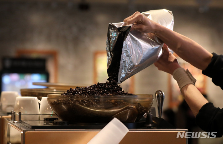 [서울=뉴시스] 커피머신에 원두를 붓고 있는 모습. (사진=뉴시스 DB). photo@newsis.com 