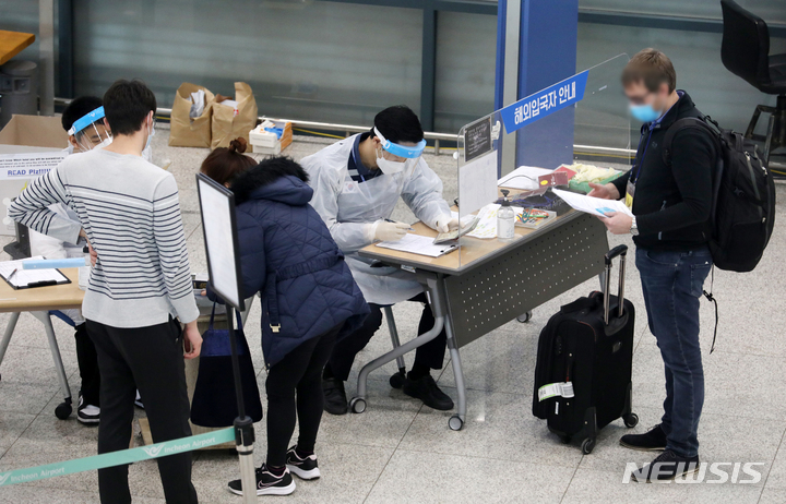 [인천공항=뉴시스] 조성우 기자 = 코로나19 백신 접종을 완료한 해외입국자 자가격리 면제가 시행된 21일 오후 인천국제공항 제1여객터미널 입국장에서 해외입국자가 여권 확인을 하고 있다. 2022.03.21. xconfind@newsis.com