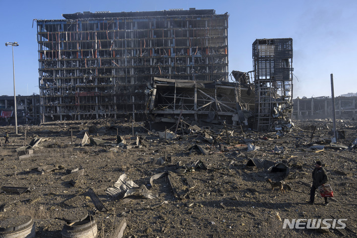 [키이우=AP/뉴시스]21일(현지시간) 우크라이나 수도 키이우(키예프)에서 한 남성이 포격으로 파괴된 쇼핑센터 건물 잔해 인근을 걷고 있다. 2022.03.21.
