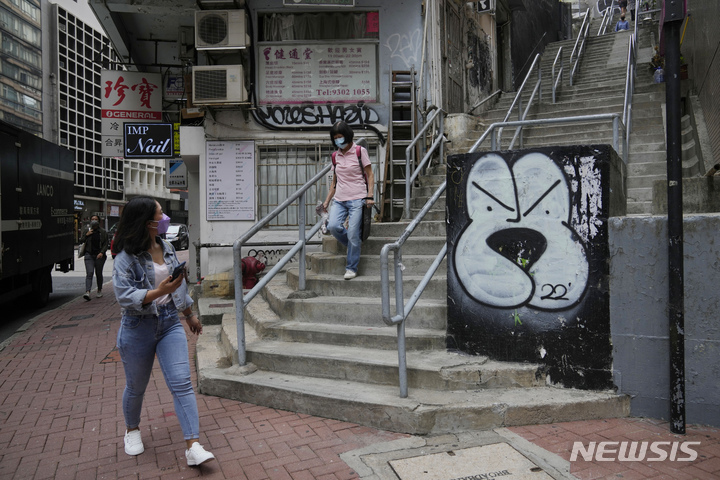[홍콩=AP/뉴시스] 지난 22일(현지시간) 마스크를 쓴 사람들이 홍콩 거리를 걷고 있다. 2022.03.22.