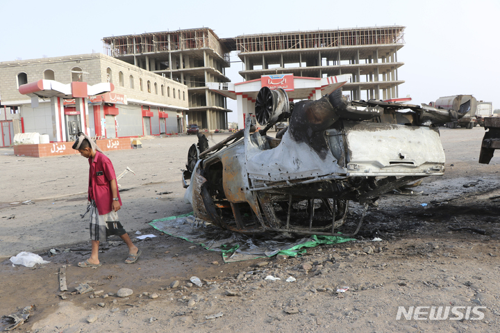 [아덴=AP/뉴시스] 예멘 항구도시 아덴에서 자동차 폭탄 테러가 발생해 총기를 든 한 남성이 현장을 살피고 있다. 현지 관계자는 이 폭발로 군 고위 간부 1명 포함 최소 5명이 숨졌다고 밝혔다. 2022.03.24.
